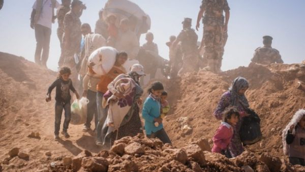 Syrians cross over the berm on their way to Jordan earlier this year (AFP)