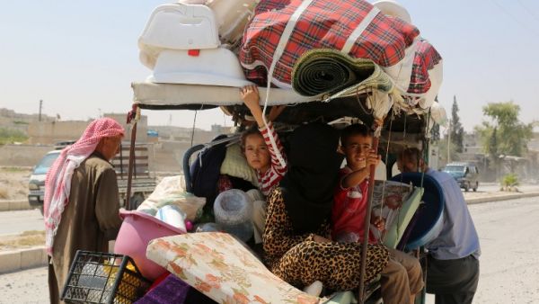 Syrian children sit in a cart, loaded with belongings, in the northern Syrian town of Manbij as civilians go back to their homes on August 14, 2016 after the Arab-Kurdish alliance, known as the Syrian Democratic Forces (SDF), pushed Daesh out of the city. (AFP/Delil Souleiman)