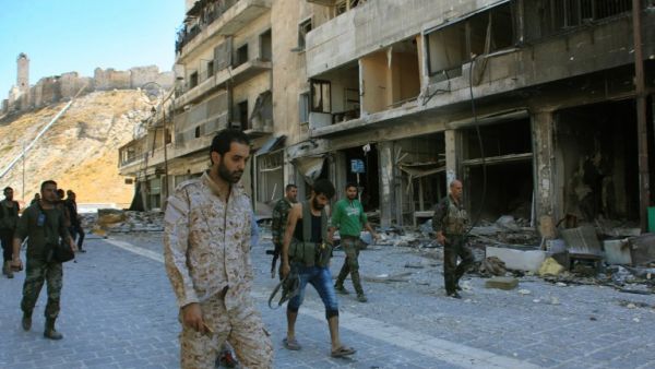 Syrian pro-government forces are seen on September 28, 2016 in the Farafira district, northwest of Aleppo's historic citadel. Syria's army took control of the rebel-held district after days of heavy air strikes that sparked allegations of war crimes. (AFP/Georges Ourfalian)