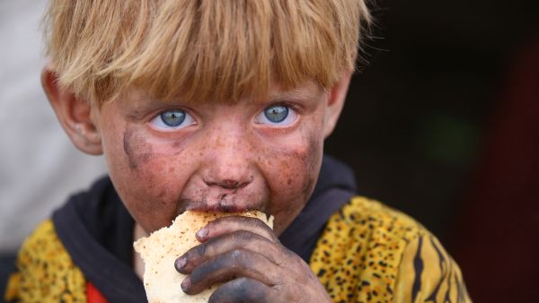 A Syrian boy eats a piece of bread in a camp for the displaced in Ain Issa, May 1 2017. (AFP/Delil Souleiman)