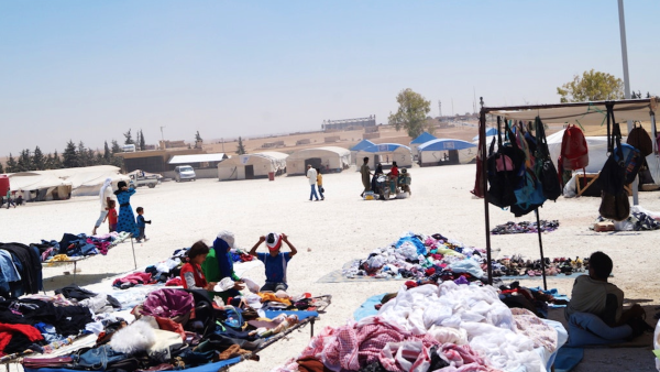 Stalls sell secondhand clothing and other items in the Ain al-Issa IDP camp. (Newsdeeply, Wladimir van Wilgenburg)