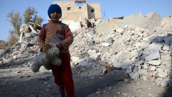 A Syrian girl, holding her stuffed toy, stands next to the rubble of buildings in the northwestern Syrian border town of al-Bab on February 25, 2017. (AFP/Nazeera al-Khatib)