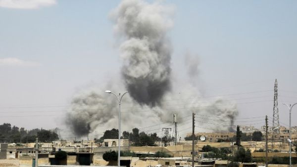 Smoke billows from buildings in the northern Syrian city of Raqa on June 18, 2017, during an offensive by US-backed fighters to retake the Islamic State (IS) group bastion. (Delil Souleiman/AFP)