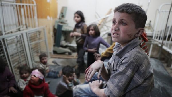 Syrian children wait to receive treatment at a makeshift clinic following reported air strikes by government forces in the rebel-held town of Douma, on the eastern outskirts of Damascus, on April 4, 2017. (AFP/Abd Doumany)