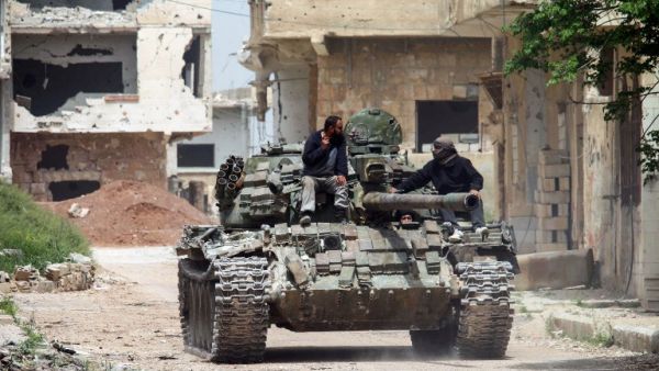 Syrians ride on the turret of a moving tank in the rebel-held area of Daraa, in southern Syria, on April 12, 2017. (AFP/Mohamad Abazeed)