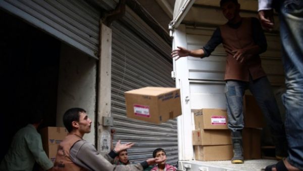 Members of the Syrian Arab Red Crescent delivering aid to a regime-besieged town. (AFP/File)