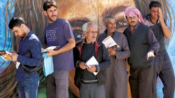 Syrian refugees queue to register their names for employment at the Zaatari refugee camp, on October 4. (AFP)