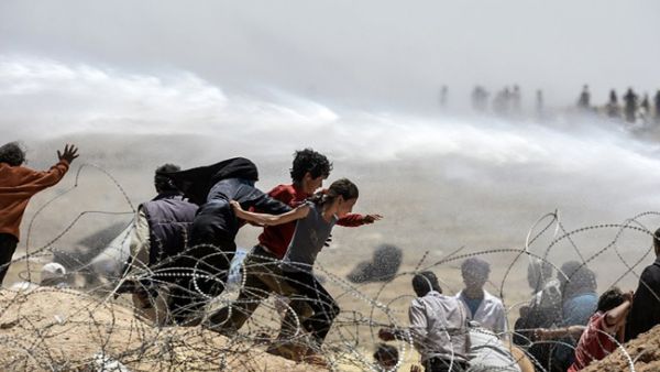 Syrians are seen attempting to flee over the Turkish border earlier last year. Turkey has been criticized for its porous border with Syria amid continued allegations that it is arming militant groups inside Syria. (AFP/File)