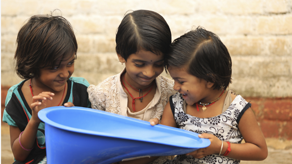 Three girls in India holding a SATO product. Credit ©LIXIL.