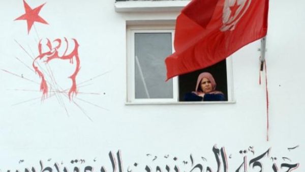 تونسية تطل من نافذة بيتها على مراسم تشييع بلعيد في جبل جلود مسقط رأس بلعيد/أ.ف.ب