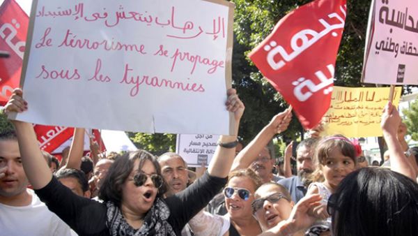Tunisian protesters hold placards and shout slogans during a protest against a controversial draft law on amnesty for corruption offences in the capital Tunis on Sept. 12, 2015. (AFP)