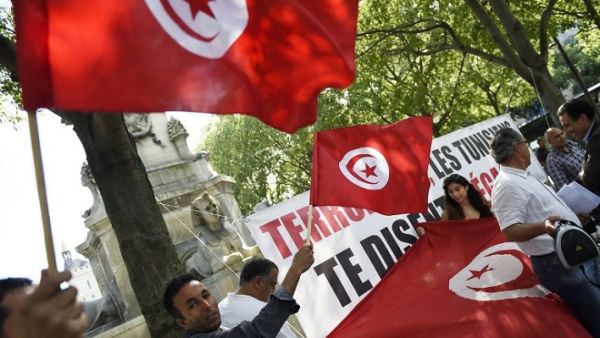 Protesters wave Tunisian flags during a demonstration against terrorism in Paris on June 27, 2015, a day after a deadly attack on a Tunisian beach resort. (Loic Venance/ AFP)