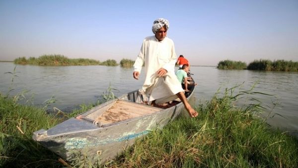 A "Marsh Arab" gets out of a boat in the al-Ahwar Marshlands in Iraq (AFP)