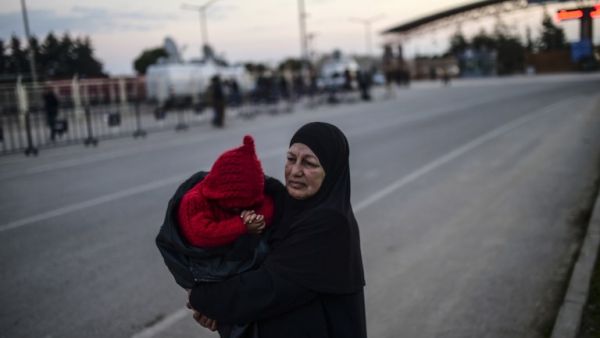 Syrian refugees wait for other family members to cross the border into Turkey. (AFP/File)