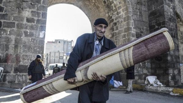 A displaced Kurdish man carries his belongings in Diyarbakir. (AFP/File)