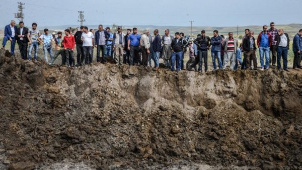 People look in a huge crater after a powerful blast on May 13, 2016 in the area of Sarikamis on the outskirts of the majority Kurdish city of Diyarbakir. (AFP/Ilyas Akengin) People look in a huge crater after a powerful blast on May 13, 2016 in the area of Sarikamis on the outskirts of the majority Kurdish city of Diyarbakir. (AFP/Ilyas Akengin)