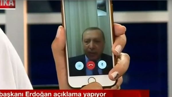 A Turkish TV presenter holds up her iPhone during a FaceTime call with President Recep Tayyip Erdogan as a coup attempt was underway. (Twitter)