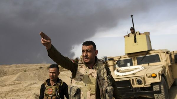 A member of Iraqi forces gestures as troops head to the frontline on October 18, 2016 near the town of Qayyarah, south of Mosul, during the operation to recapture the city from Daesh. (AFP/Bulent Kilic)