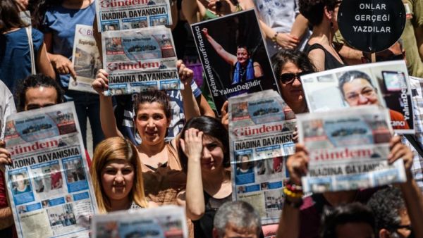Protesters hold pictures of jailed RSF representative Erol Onderoglu, journalist Ahmet Nesin and rights activist and academic Sebnem Korur Fincanci as they shout slogans in front of the Pro Kurdish Ozgur Gundem newspaper's headquarters on June 21,2016 in Istanbul. (AFP/Ozan Kose)