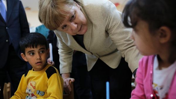 German Chancellor Angela Merkel talks with refugee children at a preschool, during a visit to a refugee camp on April 23, 2016 (AFP/File)