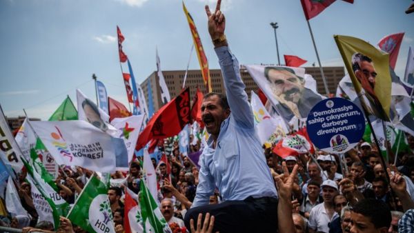Supporters of pro-Kurdish Peoples' Democratic Party (HDP) flash victory signs and shout slogans against government on June 5, 2016 in Istanbul during a rally on the lawmakers' immunity. (AFP/Ozan Kose)