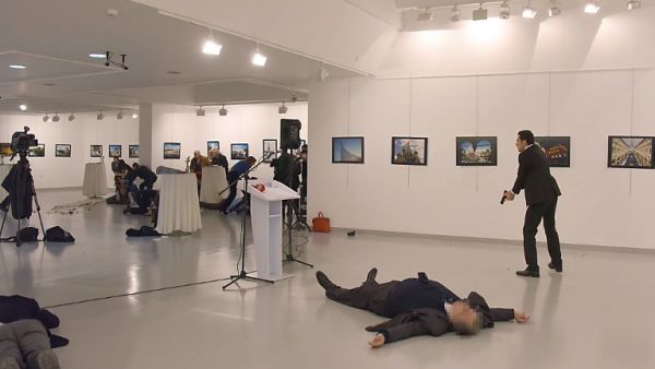 This picture taken on December 19, 2016 shows Andrey Karlov (2ndR), the Russian ambassador to Ankara, lying on the floor after being shot by a gunman (R) during an attack during a public event in Ankara. (AFP/Stringer)