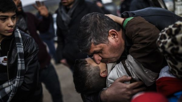Syrian father Ali embraces one of his children, Zeyn, upon their arrival from the Syrian city of Idlib to the Turkish crossing gate of Cilvegozu in Reyhanli in Hatay near the Syrian border on December 17, 2016. (AFP/Bulent Kilic)