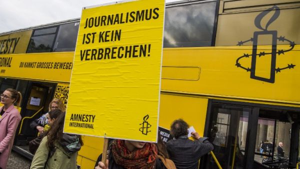 Placard reads "journalism is not a crime" at concert in Berlin on International Press Freedom Day (John Macdougall/AFP)