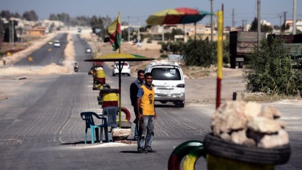 Back in 2012, a Kurdish man guards a checkpoint on the road to the city of Afrin near the Syria-Turkey border (AFP)