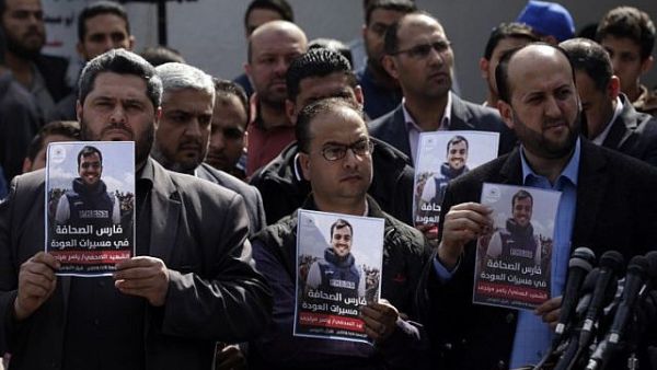 Turkish journalists stand with posters of Yasser Mortaja who was shot dead by the Israeli army while covering the Great March of Return protest in Gaza. (AFP/ File Photo) 