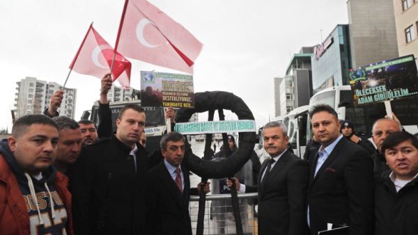 Members of the Turkish association for International Peace and Friendship (Ubdder) and ruling Justice and Development (AKP) party, gather after putting a black wreath at a blockade of anti-riot police vehicles by the Dutch embassy after the area was sealed off for "security reasons." (AFP/Adem Altan)