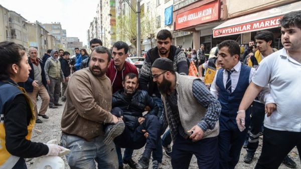 People carry an injured man near the site of an explosion at the police headquarters in Diyarbakir, southeastern Turkey, on April 11, 2017. (AFP/Ilyas Akengin)