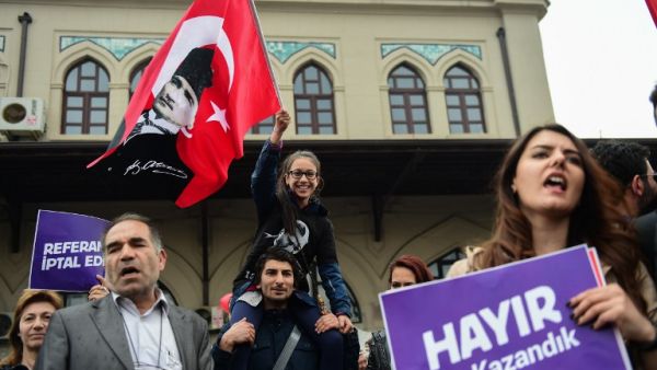 Demonstrators hold a flag of Mustafa Kemal Ataturk, founder of modern Turkey and a placard reading "No! This is just the beginning" during a protest at the Kadikoy district in Istanbul on April 23, 2017 following the results in a nationwide referendum that will hugely enhance the president Recep Erdogan powers. (AFP/Yasin Akgul)