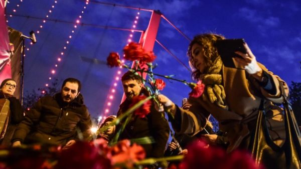 People lay flowers Tuesday in front of a memorial at the Reina nightclub, scene of Istanbul's deadly New Year's attack. (AFP/Yasin Akgul) 