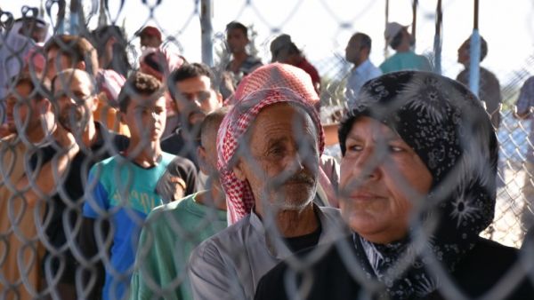 Displaced Syrians queue at a Kurdish controlled checkpoint between the rebel-held town of Azaz in northern Syria and the city of Afrin, along Syria's northern border with Turkey, as they attempt to cross on June 9, 2017. (George Ourfalian/AFP)