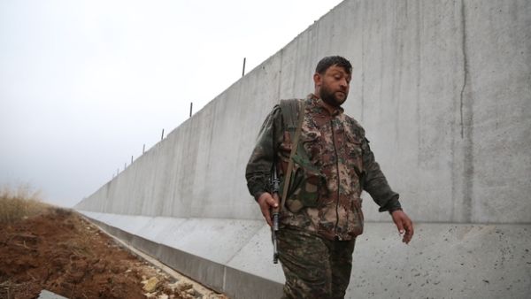 A YPG fighter walks along the Turkish-Syria border wall. (AFP/File) A YPG fighter walks along the Turkish-Syria border wall. (AFP/File)