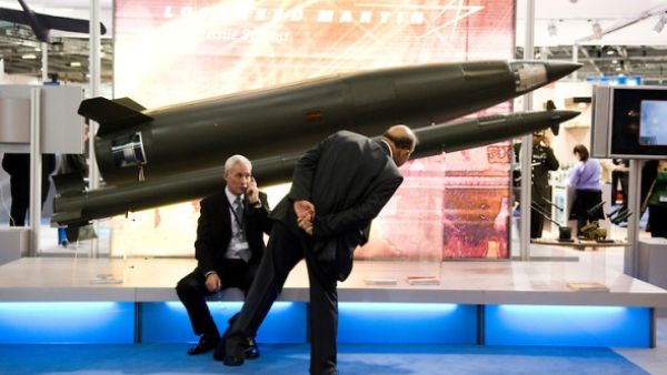 A prospective buyer inspects replica Lockheed Martin rockets at the 2013 DSEI arms fair in London. (Creative Commons)