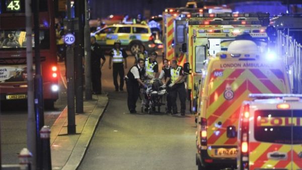 Police officers and members of the emergency services attend to a person injured in a terror attack on London Bridge in central London on June 3, 2017. (AFP/ Daniel Sorabji)