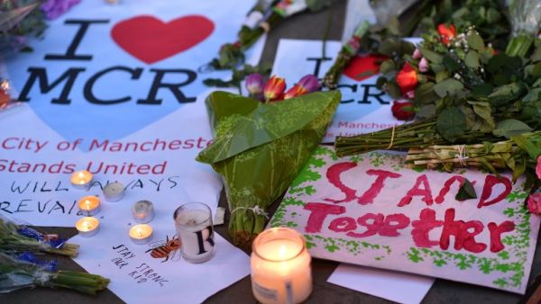 Messages and floral tributes are seen in Albert Square in Manchester, northwest England on May 23, 2017, in solidarity with those killed and injured in the May 22 terror attack at the Ariana Grande concert at the Manchester Arena. (AFP/Ben Stansall)