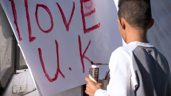 A young of immigrant origin paints the words 'I love UK' on a banner. (AFP/ File Photo)