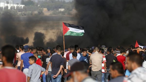 Palestinian protesters wave their national flag as they gather during a demonstration at the Israel-Gaza border, east of Khan Yunis in the southern Gaza Strip on August 10, 2018. (Said KHATIB / AFP)
