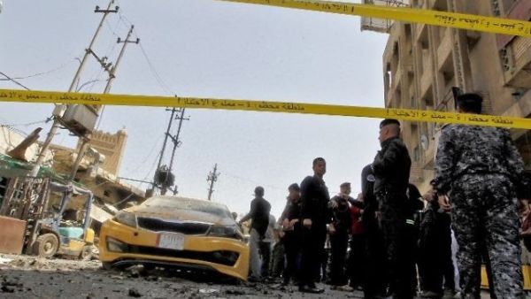 Iraqis gather at the site of a car bomb explosion near Baghdad's Al-Shuhada Bridge. (AFP/Sabah Arar)
