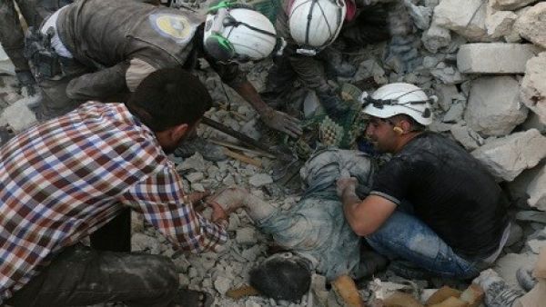 Members of The White Helmets retrieve a body from the rubble in Aleppo (AFP/Ameer Alhalbi)