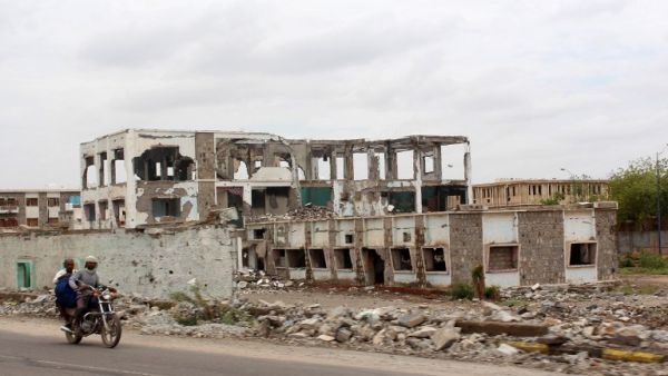 Yemeni ride past a damaged building outside of Aden. After a year of fighting, the destruction is widespread. (AFP/Saleh al-Obeidi)
