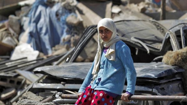 A Yemeni girl sits inside the rubble of her home (Mohammed Huwais/AFP)