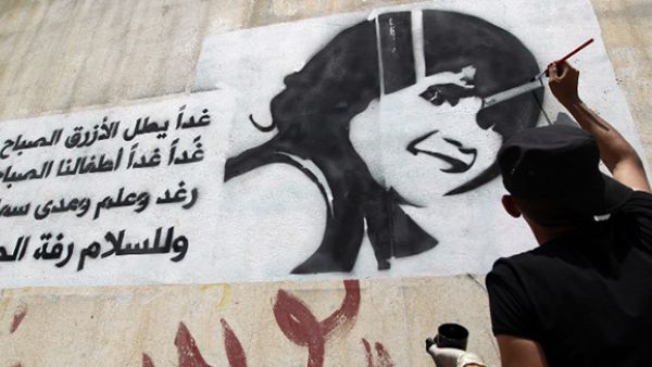 A Yemeni man paints the face of a child on a wall in the capital Sanaa, to raise awareness about the death and exploitation of children in war. The writing in Arabic is part of the lyrics of a Lebanese song about children.  (AFP/File)
