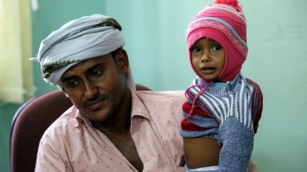 A Yemeni father carries his child suspected of being infected with cholera, as he waits to be seen at a hospital in the Yemeni coastal city of Hodeidah on November 5, 2017. (Abdo Hyder/AFP)