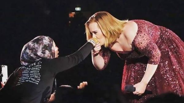 Adele kissing a Muslim fan's hand. (Twitter)