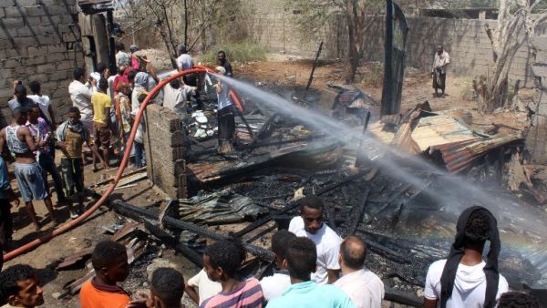 Yemenis extinguish fire at the scene of two suicide blasts which provoked the explosion of a motorbike in Dar Sad, north of the southern Yemeni port city of Aden, on March 16, 2016. (Saleh al-Obeidi)