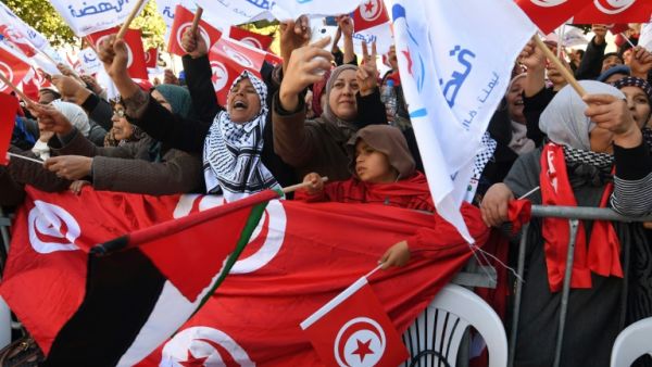 Tunisians wave their national flag and the flag of the Ennahda Islamist party. (AFP/ File)
